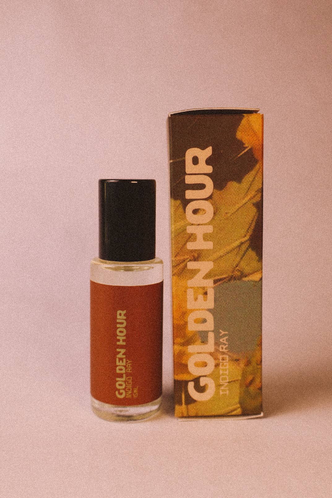 Vegan roll on perfume oil with jojoba base and golden botanical packaging photographed in soft natural light