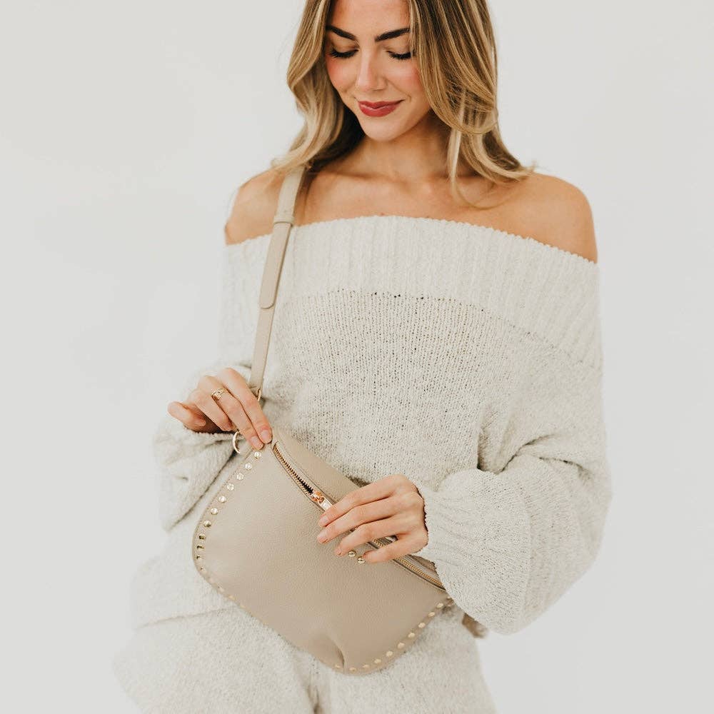 Beige studded bum bag with adjustable strap styled with a soft cream knit outfit and minimal neutral aesthetic