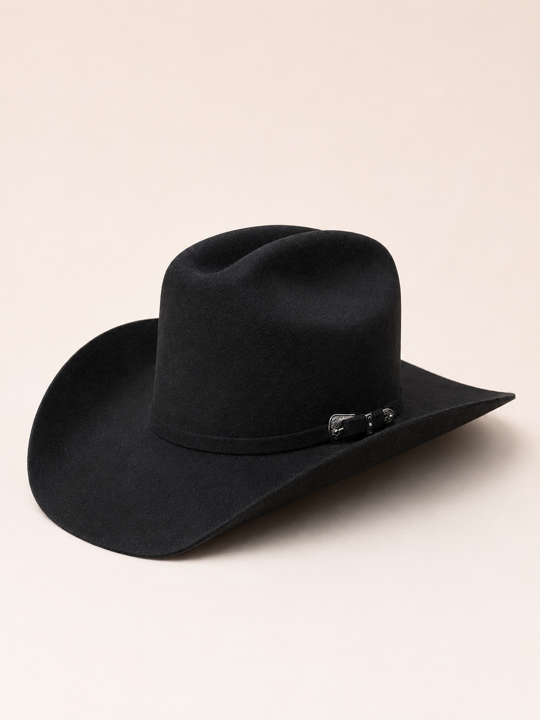 A charcoal wool felt cowboy hat with a wide brim and a decorative black bow detail on the band, photographed on a solid light beige background.