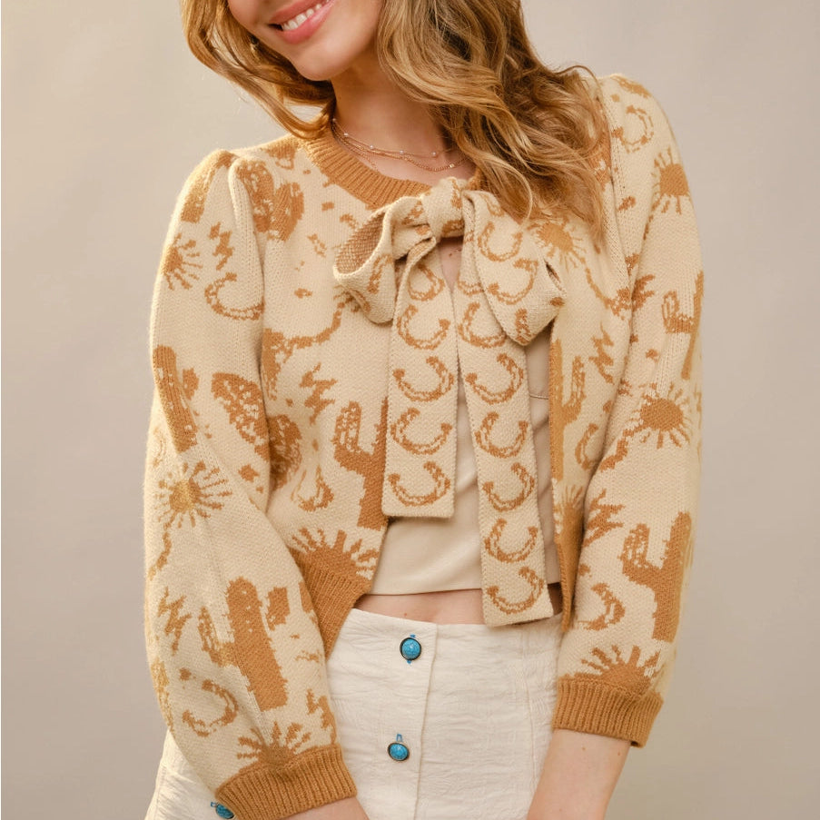 Woman wearing a patterned cardigan with a neutral background