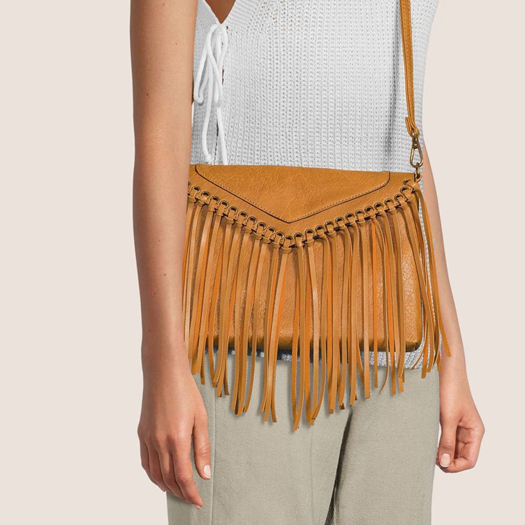 Brown fringe handbag worn by a person on a beige background