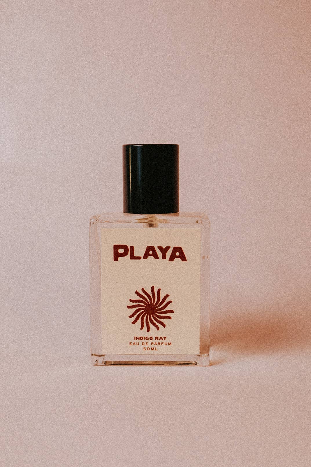 Boutique Playa fragrance bottle styled with creamy neutral tones and modern western boho beauty branding
